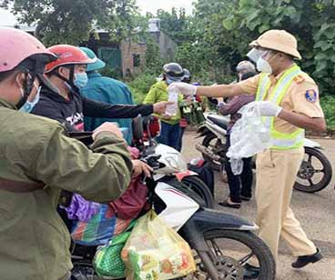 Cảnh sát Giao thông phát nước uống cho người đi đường về quê. Ảnh: Gia Cư - CSGT phát nước uống cho người đi đường về quê