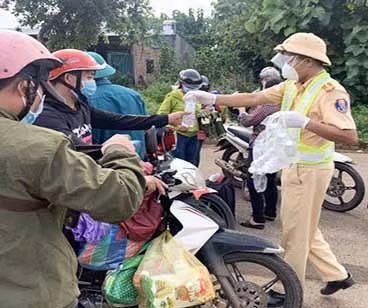 - CSGT phát nước uống cho người đi đường về quê