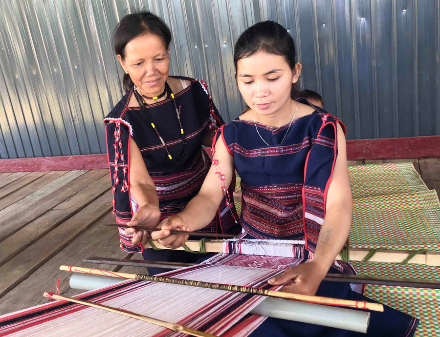 Bà Đinh Thị Drinh truyền dạy nghề dệt thổ cẩm cho thế hệ trẻ (ảnh chụp tháng 4-2021). Ảnh: Ngọc Thu