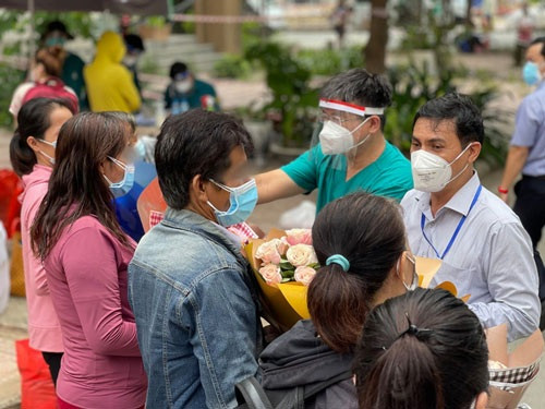 Các bệnh nhân nhận hoa từ đại diện Sở Y tế TP HCM và Bệnh viện Dã chiến thu dung điều trị Covid-19 số 7 trong ngày xuất viện. Ảnh do bệnh viện cung cấp