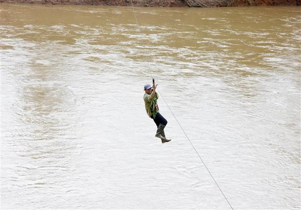 Người dân liều mình đu dây qua sông Pô Kô. (Ảnh: Khoa Chương/TTXVN)