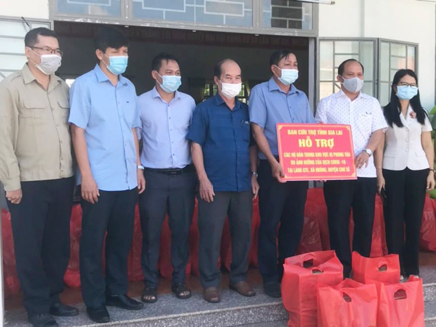  Ông Rah Lan Chung-Phó Bí thư Tỉnh ủy Gia Lai (thứ 2 từ phải sang) trao quà cho nhân dân làng Kte (xã Hbông, huyện Chư Sê) tạm thời bị phong tỏa do dịch Covid-19. Ảnh: Ngọc Anh