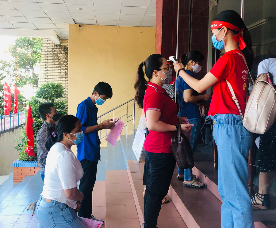Người dân đo thân nhiệt, rửa tay sát khuẩn trước khi vào hiến máu. Ảnh: Phan Lài