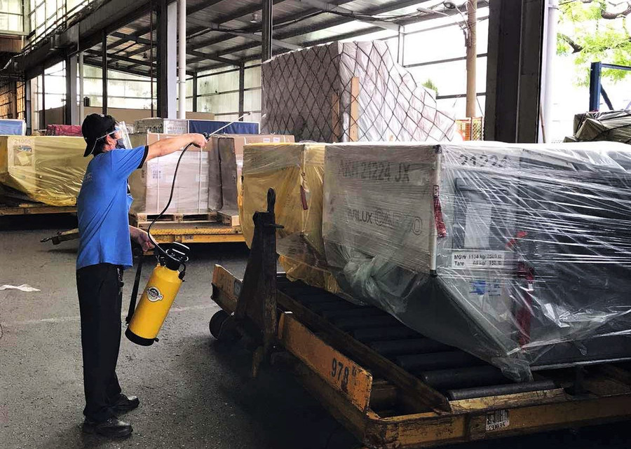 Nhân viên kho phun khử khuẩn khi tiếp nhận- Ảnh: Nguyên Vũ Nhân viên kho phun khử khuẩn khi tiếp nhận- Ảnh: Nguyên Vũ