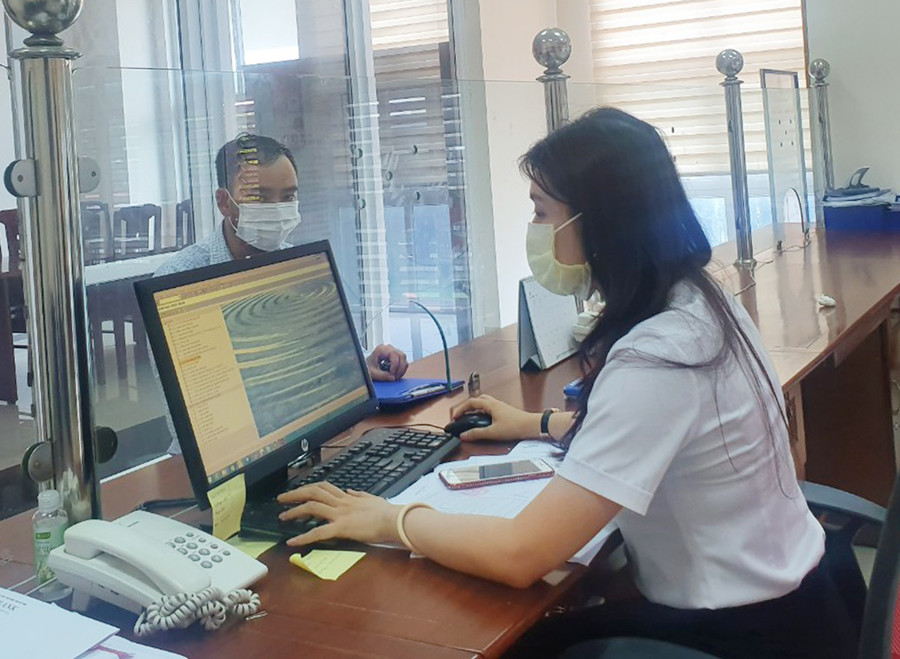 Cán bộ cơ quan Thuế hướng dẫn hộ kinh doanh kê khai thuế điện tử. Ảnh: Sơn Ca  Cán bộ cơ quan Thuế hướng dẫn hộ kinh doanh kê khai thuế điện tử. Ảnh: Sơn Ca