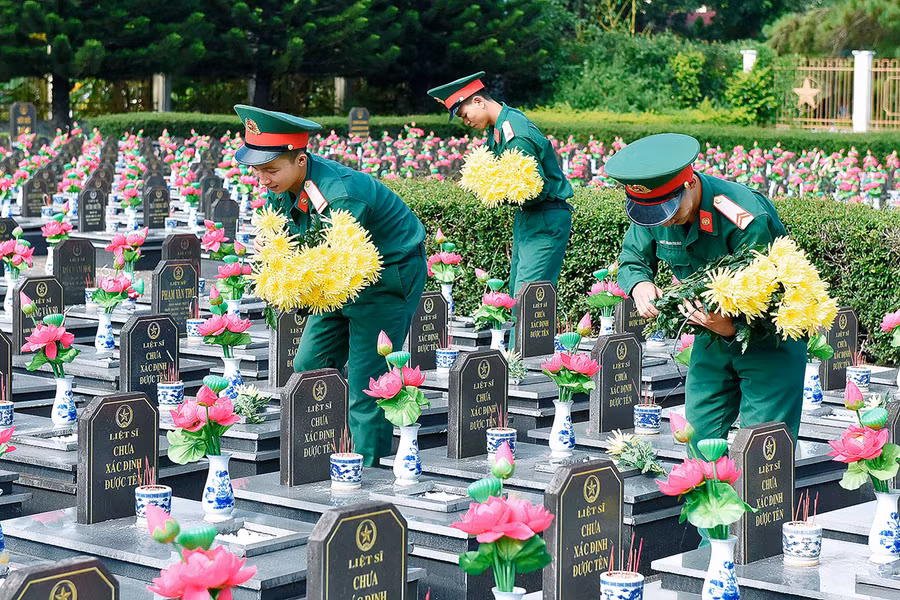 Các chiến sĩ Tiểu đoàn Thông tin 29 (Quân đoàn 3) đặt hoa trên các phần mộ liệt sĩ. Ảnh: Đức Thụy 
