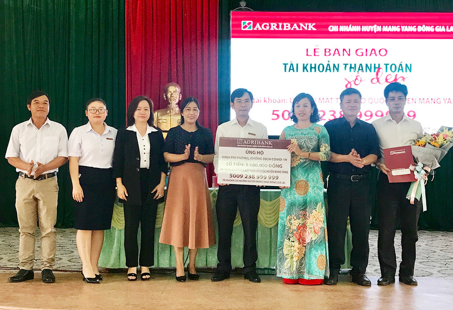  Chủ tịch Ủy ban MTTQ huyện Mang Yang Nguyễn Thị Thanh Nga (mặc bộ áo dài) tiếp nhận số tài khoản kèm kinh phí do Agribank Chi nhánh huyện Mang Yang ủng hộ phòng chống dịch Covid-19. Ảnh: Thanh Nhật