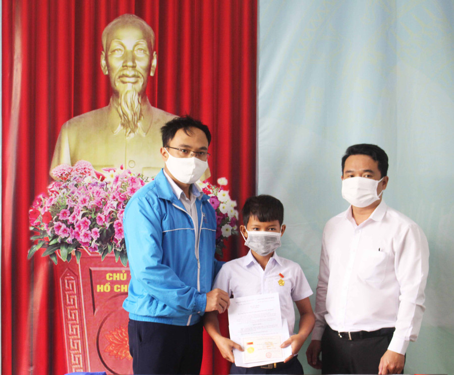 Anh Đỗ Duy Nam (bìa phải)-Phó Bí thư Tỉnh Đoàn, Chủ tịch Hội đồng Đội tỉnh trao tặng huy hiệu Tuổi trẻ dũng cảm cho em Kpă Khoa (ở giữa). Ảnh P.L