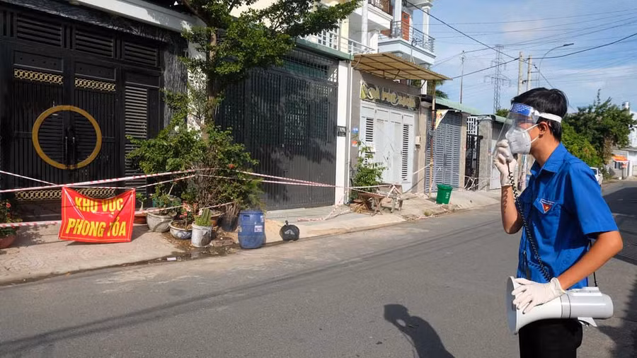 Mỗi buổi sáng, nhóm tình nguyện sẽ phát loa thông báo trước khu phong tỏa để đi chợ giúp người dân. Ảnh: SONG MAI