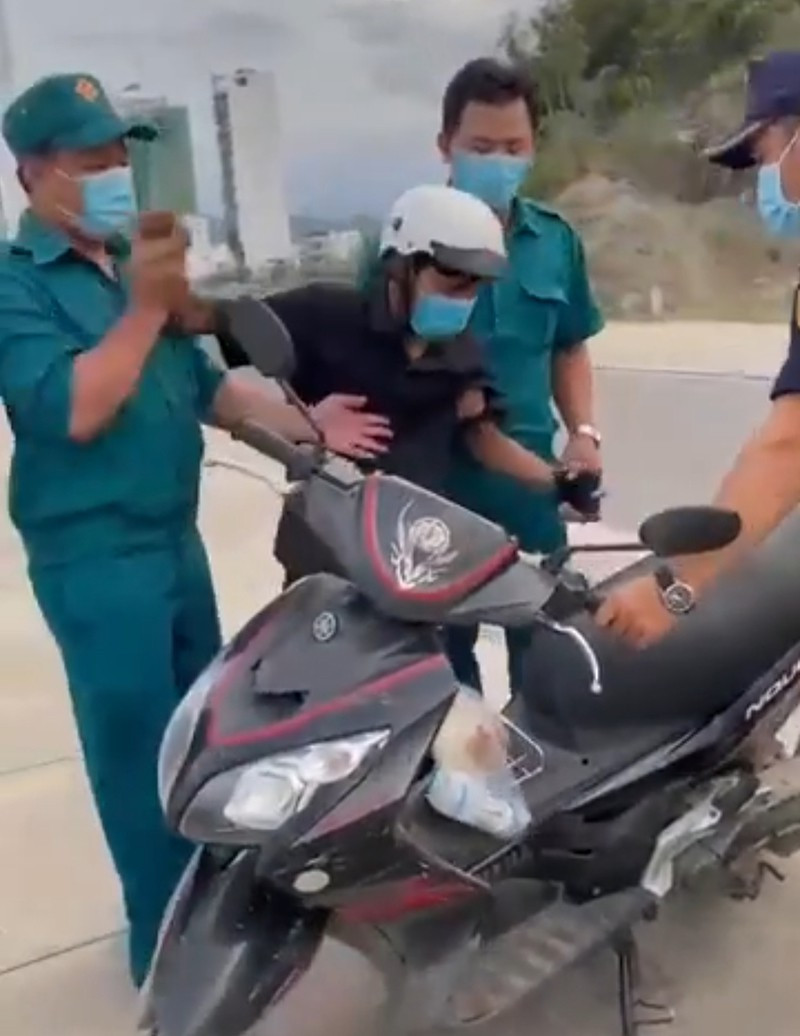  Lực lượng chức năng phường Vĩnh Hòa thu xe máy của công nhân đi mua bánh mỳ. Ảnh cắt từ clip.