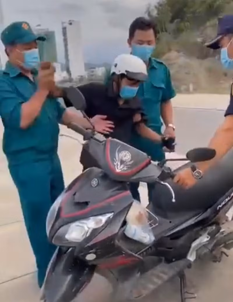  Lực lượng chức năng phường Vĩnh Hòa thu xe máy của công nhân đi mua bánh mỳ. Ảnh cắt từ clip.