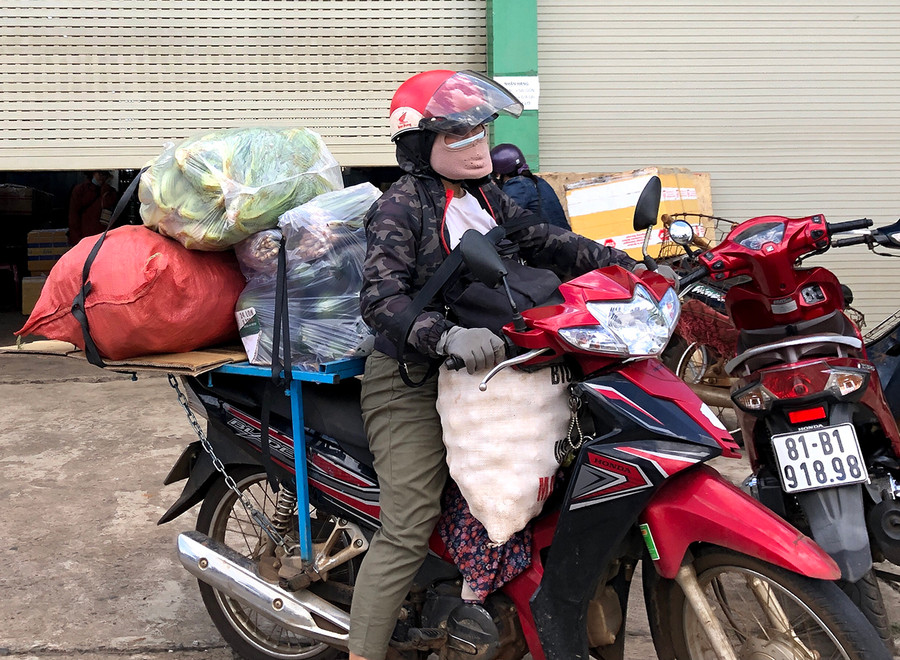 Người phụ nữ chở nặng một xe rau củ đến để gửi đi TP. Hồ Chí Minh nhưng xe đã hết chỗ, đành quay về.
