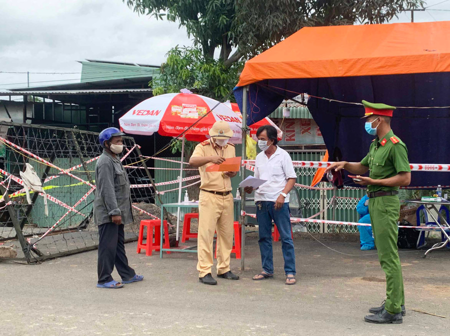 Lực lượng chức năng hướng dẫn người dân các thủ tục cần thiết khi qua chốt kiểm dịch.Ảnh.Vũ Chi