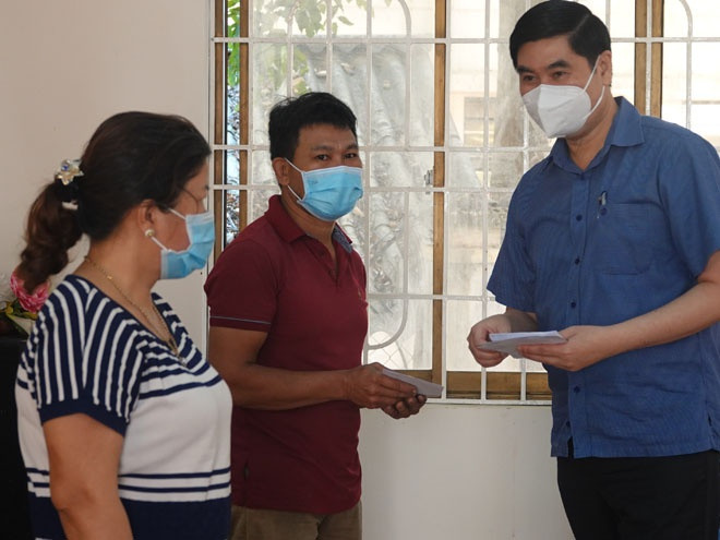 Phó chủ tịch UBND tỉnh Bình Định Lâm Hải Giang (bìa phải) trao tiền hỗ trợ cho người dân gặp khó khăn do ảnh hưởng Covid-19- ẢNH: HOÀNG TRỌNG
