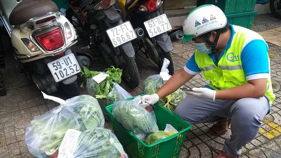 Shipper tình nguyện tại P.10, Q.11 kiểm tra hàng hóa trước khi giao cho người dân. ẢNH: MINH NHỰT