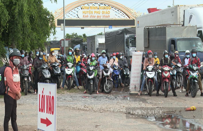 Hàng người (chủ yếu đi xe gắn máy) đang sẳn sàng chờ làm thủ tục y tế để vào địa phận tỉnh Bình Phước. Ảnh: T.N