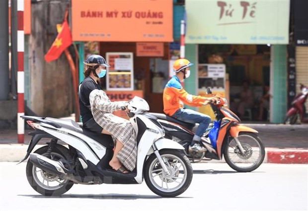  Người dân che, chắn trong đợt nắng nóng cục bộ tại Hà Nội. (Ảnh: Hoàng Hiếu/TTXVN)