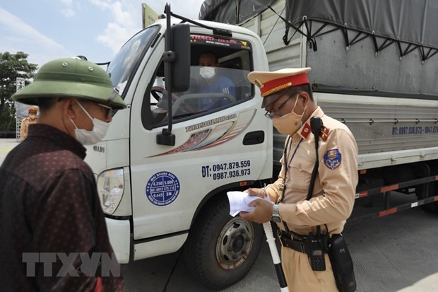 Phương tiện chở hàng thiết yếu sẽ được kiểm tra các điều kiện đảm bảo an toàn phòng, chống dịch COVID-19 khi qua chốt. (Ảnh: Minh Quyết/TTXVN)