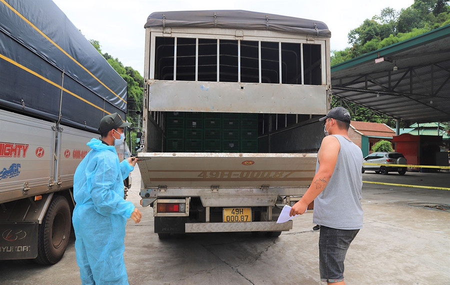 Cơ quan chức năng kiểm tra các thùng xe tải đảm bảo công tác phòng chống dịch tại Chốt số 1. ẢNH: TRÙNG DƯƠNG