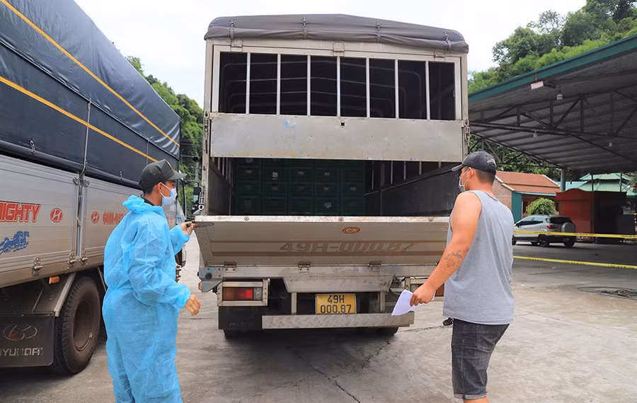 Cơ quan chức năng kiểm tra các thùng xe tải đảm bảo công tác phòng chống dịch tại Chốt số 1. ẢNH: TRÙNG DƯƠNG