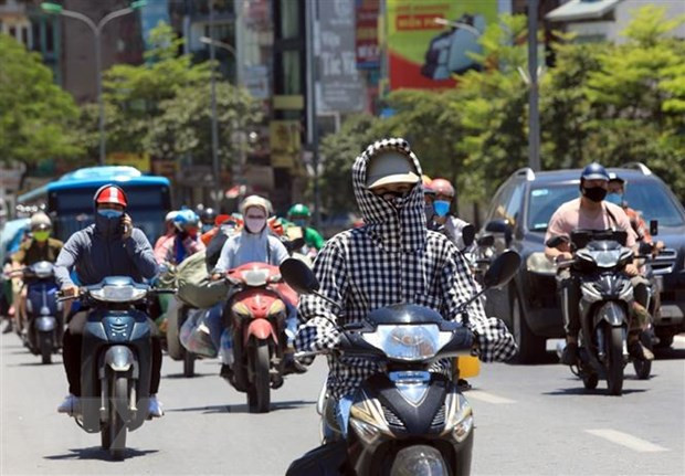  Người dân đi trên đường phải bịt kín để bảo vệ cơ thể dưới trời nắng. (Ảnh: Phan Tuấn Anh/TTXVN)