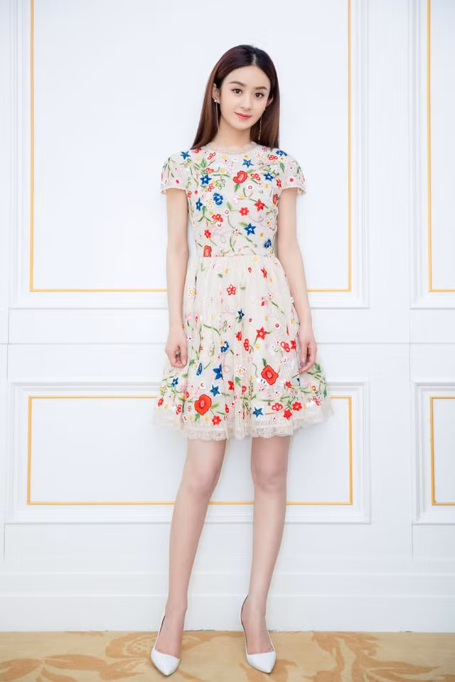 Chiếc váy in họa tiết tạo cho mỹ nhân Cbiz vẻ ngoài trẻ trung và lãng mạn với thiết kế váy ngắn chất liệu vải tuyn màu nude và những cụm hoa thêu bằng len nhiều màu sắc.