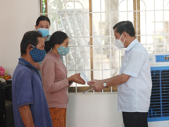 Ông Phạm Trương, Bí thư kiêm Chủ tịch UBND TX.Hoài Nhơn (bìa phải), trao tiền hỗ trợ cho người dân- ẢNH: HOÀNG TRỌNG