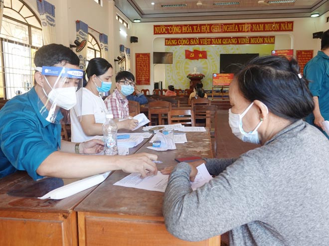 Cán bộ P.Tam Quan Nam (TX.Hoài Nhơn) hướng dẫn lao động tự do làm hồ sơ hỗ trợ-ẢNH: HOÀNG TRỌNG