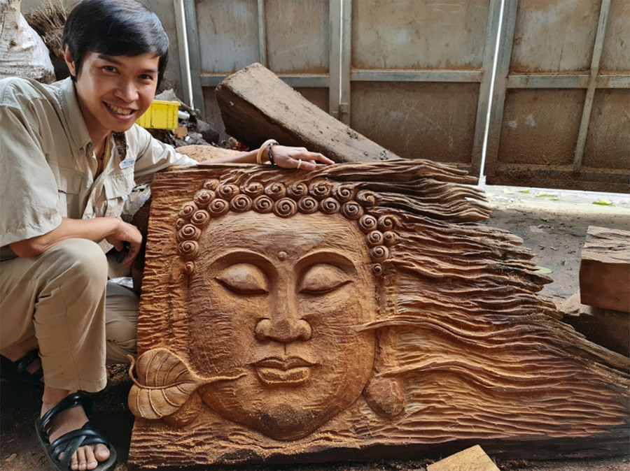 Anh Ngô Quý Đức bên sản phẩm làng nghề. ẢNH: NVCC