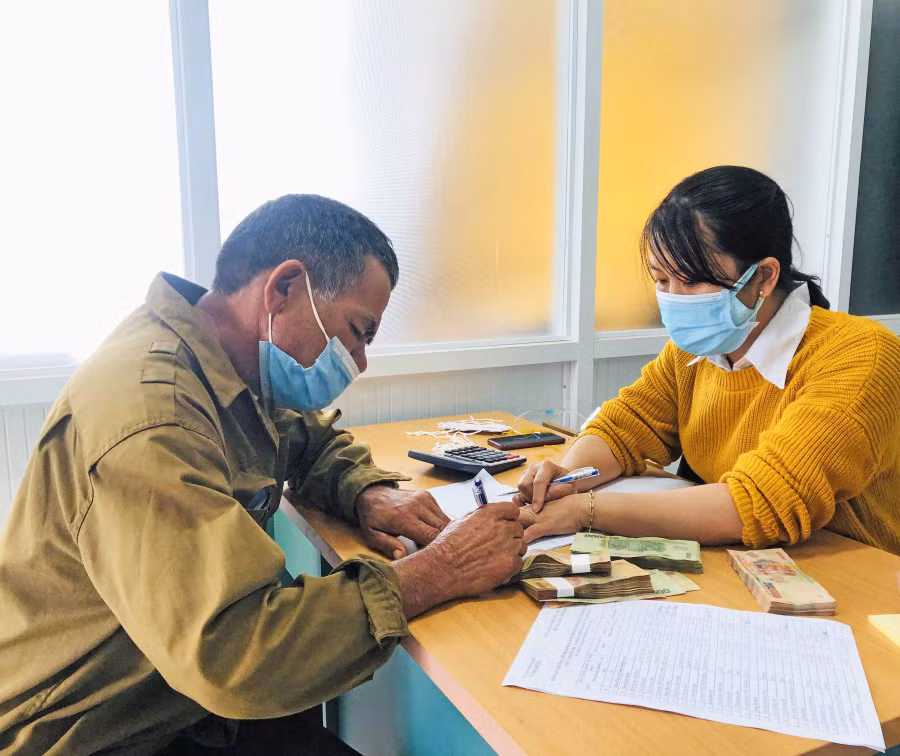 Cán bộ kế toán xã Đak Djrăng (huyện Mang Yang) chi trả tiền phụ cấp cho người hoạt động không chuyên trách. Ảnh: Thủy Bình