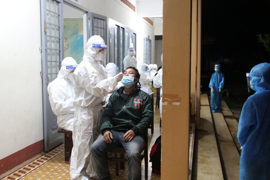 Nhân viên y tế lấy mẫu test nhanh những người trở về từ Đồng Nai. Ảnh: Hoàng Bình