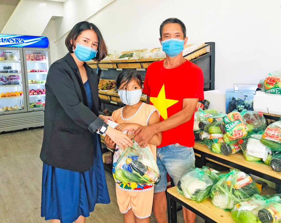 Chị Nguyễn Xuân Quỳnh-chủ cửa hàng Hoa quả Gia Lai tặng quà cho người dân khó khăn. Ảnh: Thủy Bình