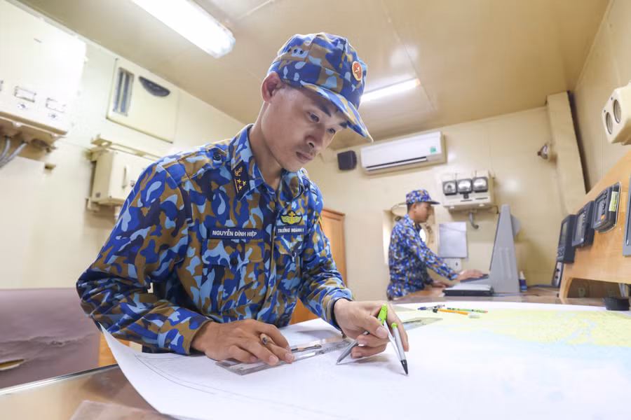 Tác nghiệp hải đồ trong quá trình diễn tập bắn đạn thật ở phòng chỉ huy tàu hộ vệ săn ngầm Petya. ẢNH: NGÔ TRẦN HẢI AN