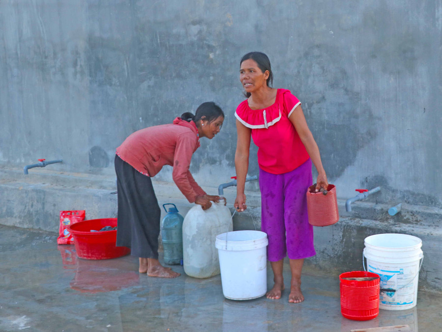 Người dân làng Nhoi (xã Tú An, thị xã An Khê) ra bể nước chung lấy nước về sử dụng. Ảnh: Ngọc Minh