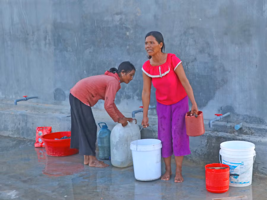 Người dân làng Nhoi (xã Tú An, thị xã An Khê) ra bể nước chung lấy nước về sử dụng. Ảnh: Ngọc Minh