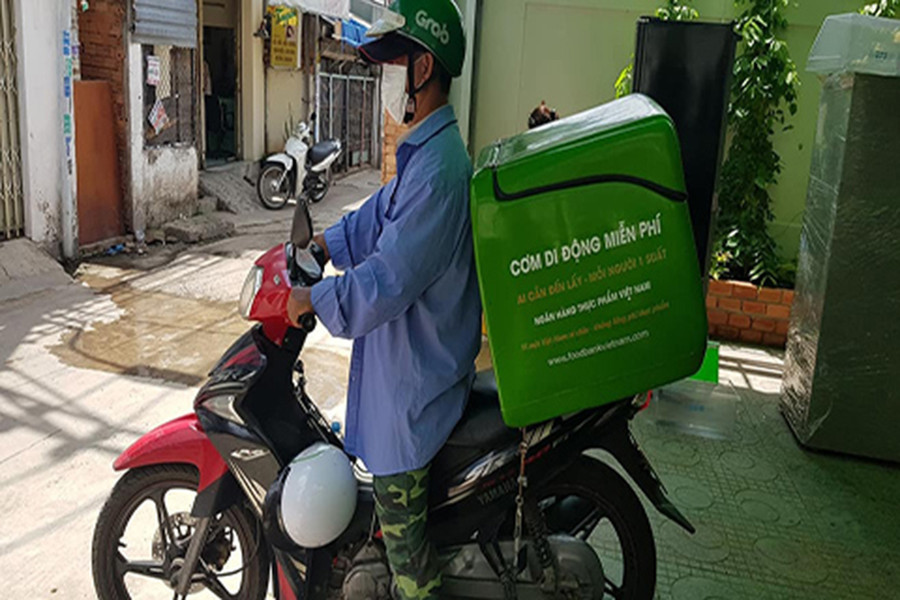  Thiện nguyện Grap miễn phí chở cơm cho người nghèo. Ảnh: Gia Cư