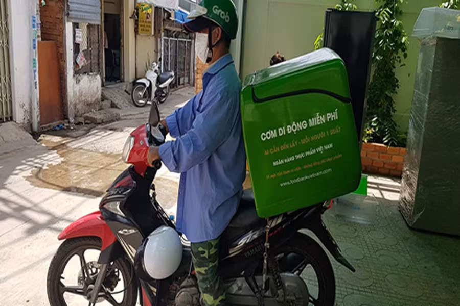  Thiện nguyện Grap miễn phí chở cơm cho người nghèo. Ảnh: Gia Cư