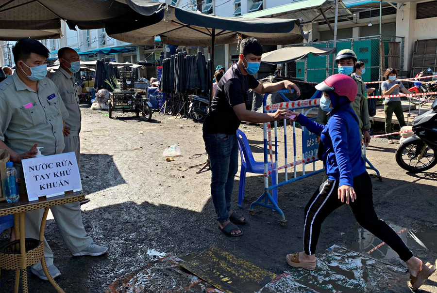 Người dân đưa phiếu để vào chợ Đầm (TP.Nha Trang) mua nhu yếu phẩm. ẢNH: PHAN LÊ