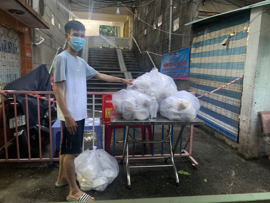 Anh Phan Văn Nhật mang suất ăn đến phát tặng ở khu vực bị phong tỏa