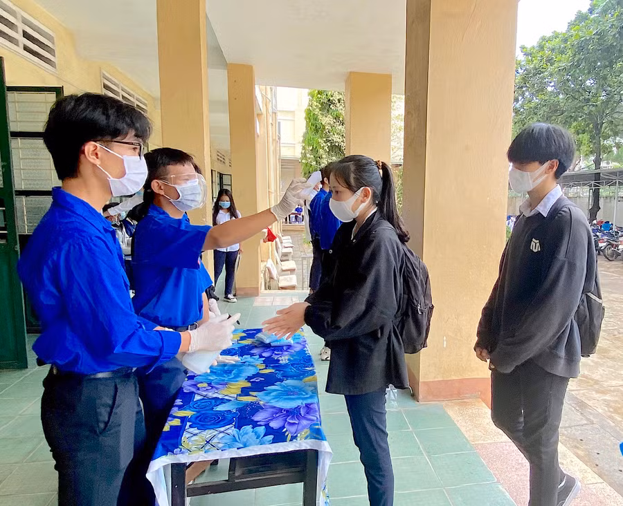 Điểm thi Trường THPT Lê Lợi (TP. Pleiku) kiểm tra thân nhiệt và khử khuẩn cho thí sinh trước khi vào khu vực thi. Ảnh: Mộc Trà