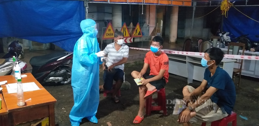 Cán bộ y tế hướng dẫn người dân làm thủ tục khai báo y tế tại chốt kiểm dịch xã Hòa Phú. (Ảnh: N.G)