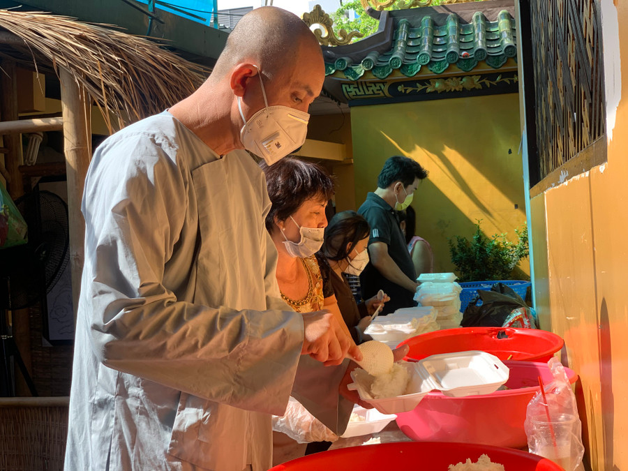 Sư thầy Thích Chí Lực, trụ trì chùa Giác Tánh, cùng phật tử chuẩn bị các suất cơm để phát tặng