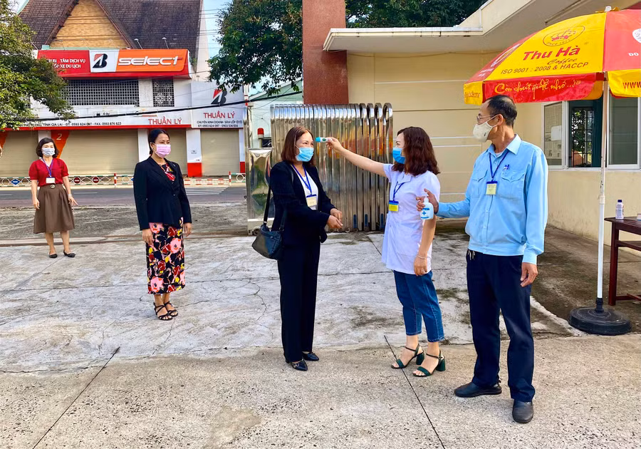 Cán bộ chấm thi được kiểm tra thân nhiệt và sát khuẩn vào đầu mỗi buổi làm việc nhằm đảm bảo an toàn phòng dịch Covid-19. Ảnh: Hồng Thi
