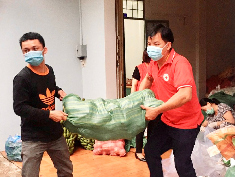 Cán bộ, nhân viên Hội Chữ thập đỏ tỉnh chuyển củ quả ra xe để vận chuyển vào TP. Hồ Chí Minh. Ảnh: Như Nguyện