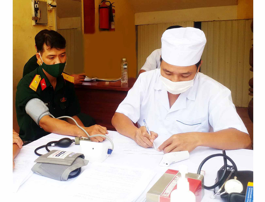 Hình 1: Các quân nhân khám sàng lọc sức khỏe trước khi tiêm. Ảnh: Kim Hồng 