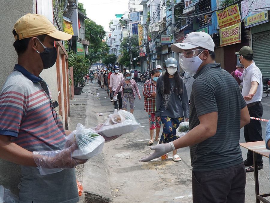 Đông đảo người khó khăn đến giáo xứ Tân Trang nhận những suất cơm được chuẩn bị sẵn. ẢNH: X.K
