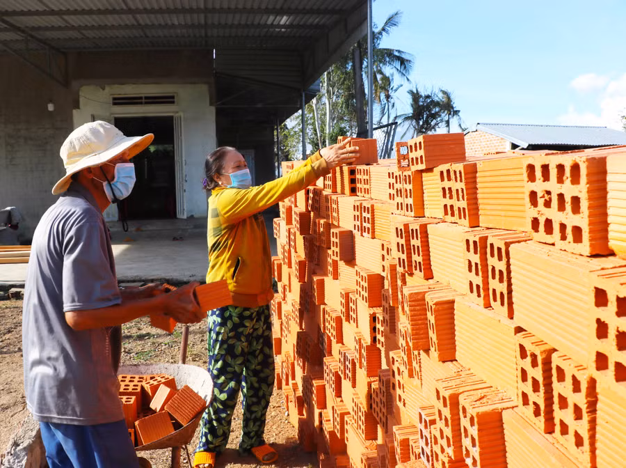 Được thị xã hỗ trợ kinh phí, ông Phạm Tấn Lực (thôn 5, xã Thành An) mua vật liệu chuẩn bị sửa chữa nhà. Ảnh: Ngọc Minh