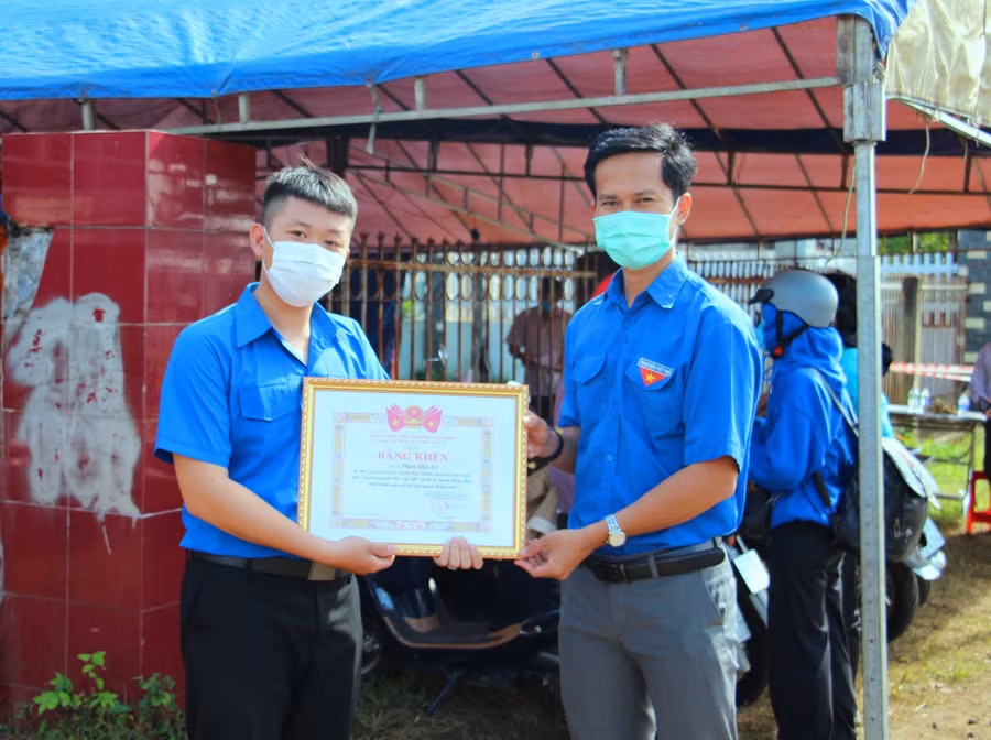 Anh Trí (trái) nhận bằng khen của Tỉnh đoàn Đắk Lắk về việc làm tốt. ẢNH: HOÀNG BÌNH