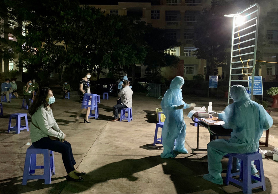 Lực lượng y tế lấy mẫu cho cán bộ giáo viên tại Trường THPT CHuyên Hùng Vương đêm 16-7. Ảnh: Như Nguyện