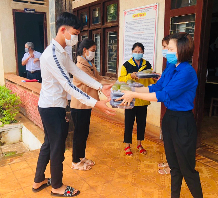 Tình nguyện viên trao suất cơm cho thí sinh ở huyện Đức Cơ. Ảnh: Phan Lài